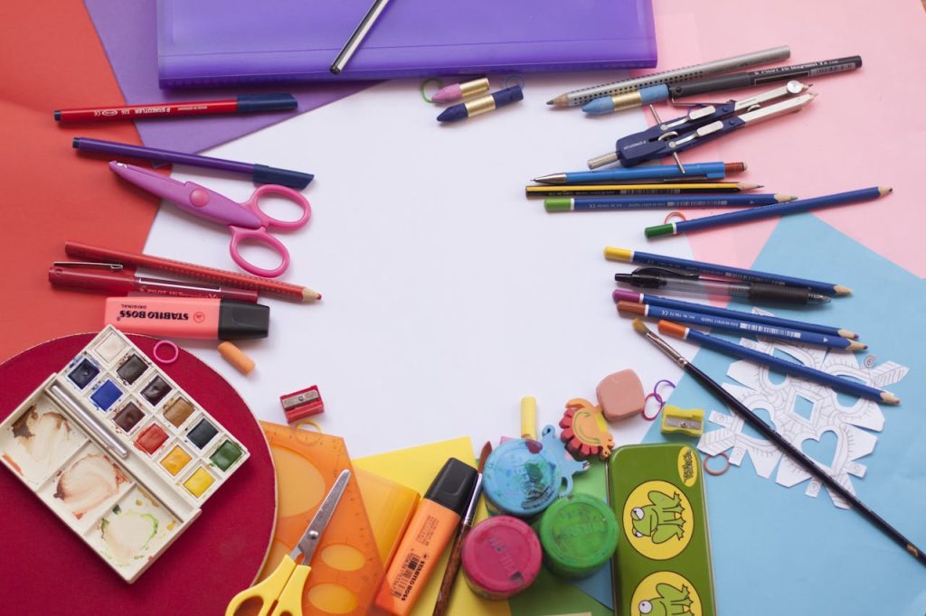 A vibrant selection of school supplies on a desk, including paints and stationery, ideal for creative projects.